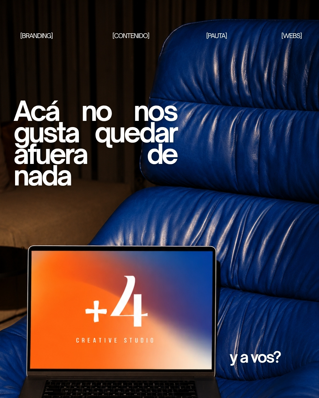 Pieza de estudio: un sillón de cuero azul y una notebook con el logo +4 en pantalla.